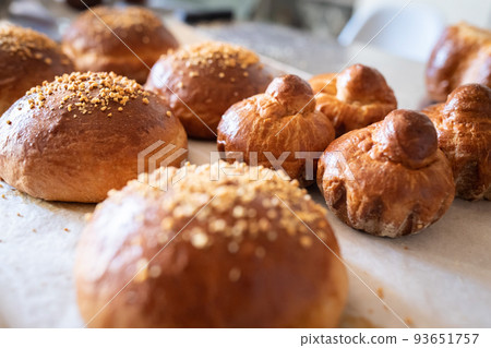 Ready-made brioches cool down on the table after baking. Front view. 93651757