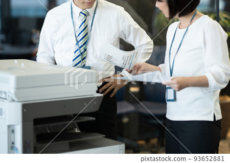 Businessman discussing materials in front of the copier Faceless 93652881