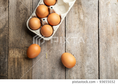 Fresh organic chicken eggs in carton or egg container on wood background. Fresh organic chicken eggs in carton or egg container on wood background. 93655032