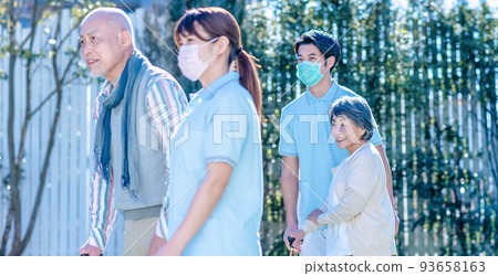 Rehabilitation Center Elderly people and care staff walking in the courtyard 93658163