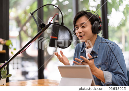 Asian male podcaster making audio podcast from her home studio 93658925