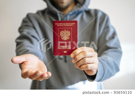 Russian passport in the hands of a man. Prohibition of Schengen visas for Russian tourists to travel to the European Union concept. 93659110
