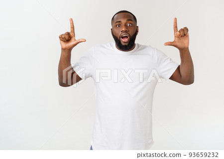 Young amazed African American pointing his finger at white background with copy space for your advertisement Young amazed African American pointing his finger at white background with copy space for your advertisement 93659232