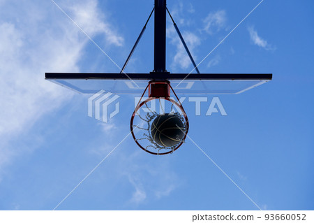 Street basketball ball falling into the hoop. Close up of black ball in the hoop net. Street basketball ball falling into the hoop. Close up of black ball in the hoop net. 93660052
