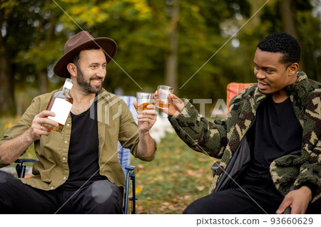 Two male friends fishing with alcoholic drinks Two male friends fishing with alcoholic drinks 93660629