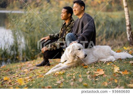Man caress dog and look away in nature at autumn Man caress dog and look away in nature at autumn 93660680