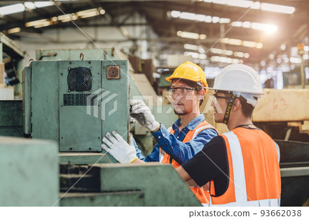 Industry worker working together training young new machine operator staff in metal factory. 93662038