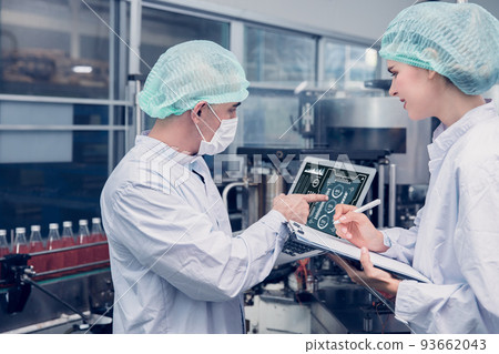 Food and Drink factory worker working together with hygiene monitor control mix ingredients machine with laptop computer 93662043