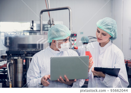 Food and Drink factory worker working together with hygiene monitor control mix ingredients machine with laptop computer Food and Drink factory worker working together with hygiene monitor control mix ingredients machine with laptop computer 93662044