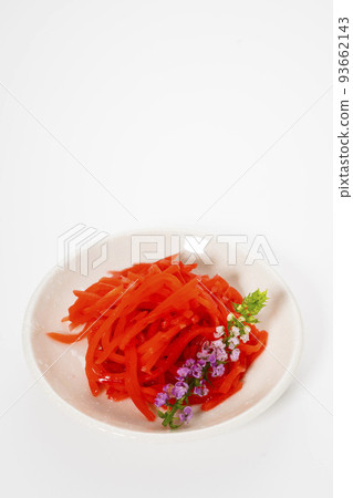 Shredded red pickled ginger on a small plate, photographed against a white background 93662143