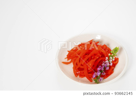 Shredded red pickled ginger on a small plate, photographed against a white background 93662145