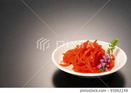 Shredded red pickled ginger on a small plate, photographed against a black background Shredded red pickled ginger on a small plate, photographed against a black background 93662149