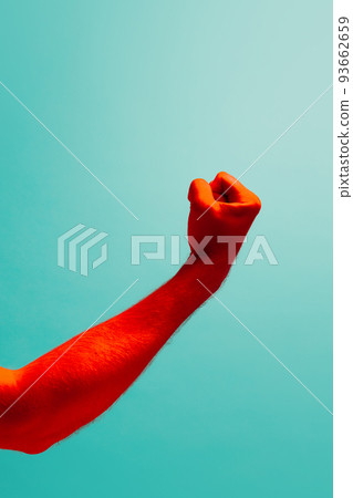 The threat. Man's hand clenched into fist isolated on light blue background in red neon light. Concept of relationship, community, care, support, symbolism, culture 93662659