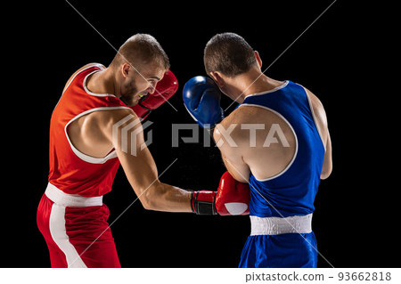 Training. Young professional boxers in red and blue sports uniform boxing isolated on dark background. Concept of sport, skills, power, training, energy 93662818