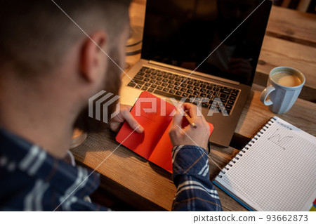 Cropped image of young man chatting via net-book during work break in coffee shop, male sitting in front open laptop computer with blank copy space screen. Cropped image of young man chatting via net-book during work break in coffee shop, male sitting in front open laptop computer with blank copy space screen. 93662873