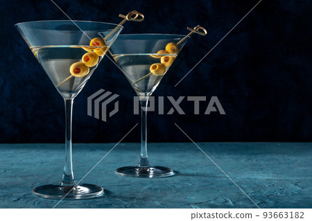 Martini, two glasses with spicy olives, on a dark blue background 93663182