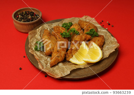 Concept of tasty food with Chicken strips on red background Concept of tasty food with Chicken strips on red background 93663239