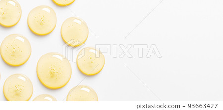 Yellow drops of gel close up. Cosmetic product for moisturizing the skin of the face or body. Copy space 93663427