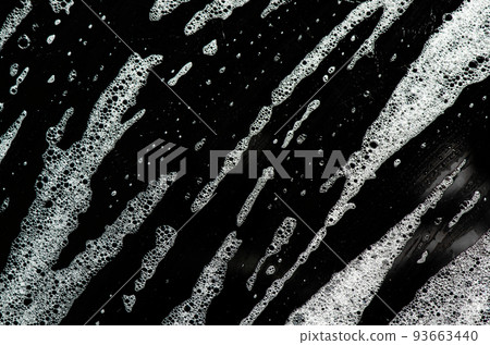 Texture of white foam on a black background. Cleansing mousse for the face or shaving foam or washing powder. Closeup 93663440