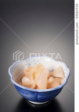 Sweet and sour pickled ginger in a small bowl against a black background Sweet and sour pickled ginger in a small bowl against a black background 93663556