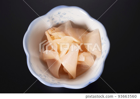 Sweet and sour pickled ginger in a small bowl against a black background Sweet and sour pickled ginger in a small bowl against a black background 93663560