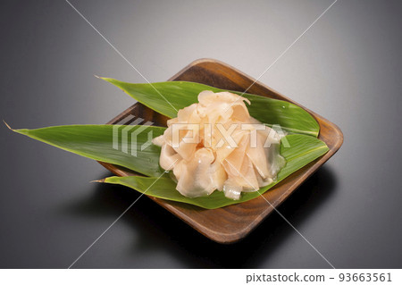A black background shot of sweet pickled ginger on a wooden plate 93663561