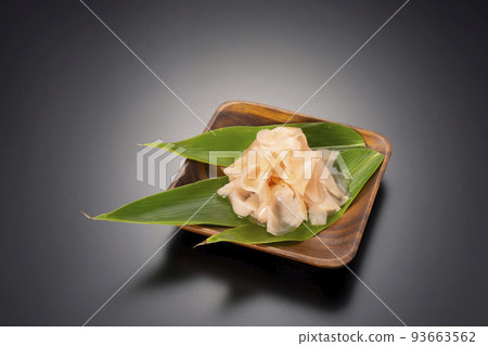 A black background shot of sweet pickled ginger on a wooden plate 93663562