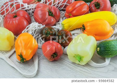 Set of farming tomatoes, peppers, zucchini in cotton bag. Zero waste shopping. Peasant style. Set of farming tomatoes, peppers, zucchini in cotton bag. Zero waste shopping. Peasant style. 93664582