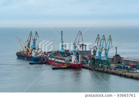 container ship is moored with the help of tugboats to a cargo berth container ship is moored with the help of tugboats to a cargo berth 93665761