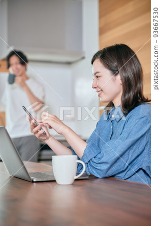 A young woman operating a smartphone during telework A young woman operating a smartphone during telework 93667530