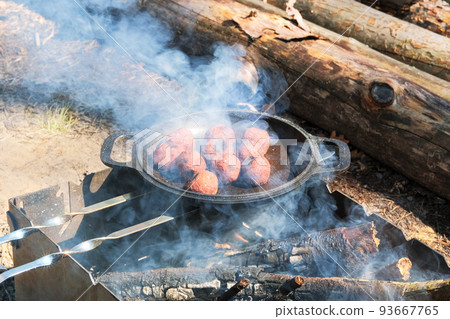 Vegan falafel cook in a pan outdoors. Middle east culture. Wood fire prepared for grill on nature. Picnic. 93667765