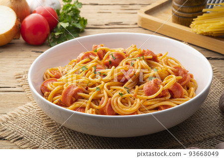 Hot dog or sausage stuffed with spaghetti in tomato pork sauce in white plate 93668049