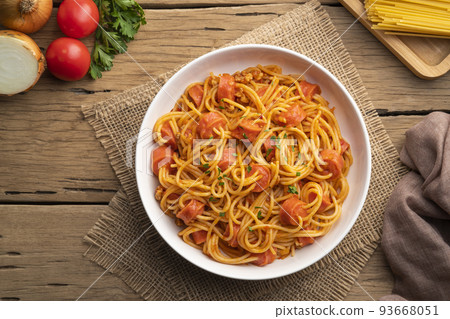 Hot dog or sausage stuffed with spaghetti in tomato pork sauce in white plate.Top view Hot dog or sausage stuffed with spaghetti in tomato pork sauce in white plate.Top view 93668051