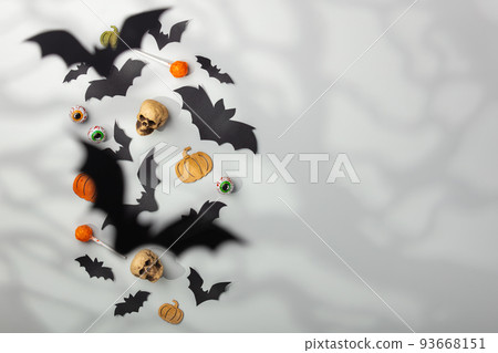 Halloween decoration concept - black paper bats, autumn leaves, sculls and candies Halloween decoration concept - black paper bats, autumn leaves, sculls and candies 93668151