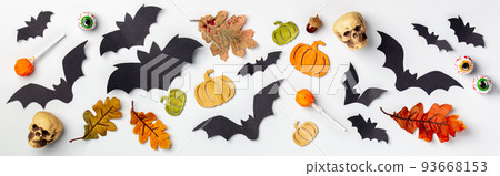 Halloween decoration concept - black paper bats, autumn leaves, sculls and candies, banner Halloween decoration concept - black paper bats, autumn leaves, sculls and candies, banner 93668153