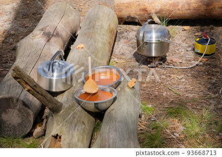 Camping food making. Soup on tourist gas burner. Camper preparing food in the forest. 93668713