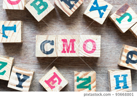 Alphabet letter block in word CMO (Abbreviation of Chief Marketing Officer, Contract Manufacturing Organization) and another letter on wood background 93668801