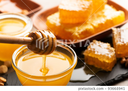 Honey on wooden honey-dipper closeup food background 93668941