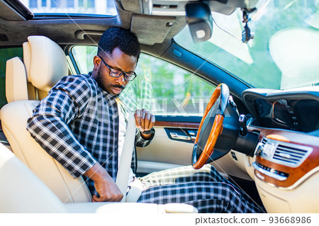 brazilian man fastening seat belt in car and ready to move 93668986