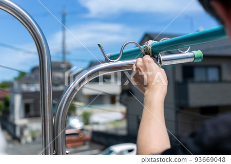 A man fixing a washing pole A man fixing a washing pole 93669048