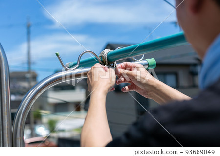 A man fixing a washing pole A man fixing a washing pole 93669049