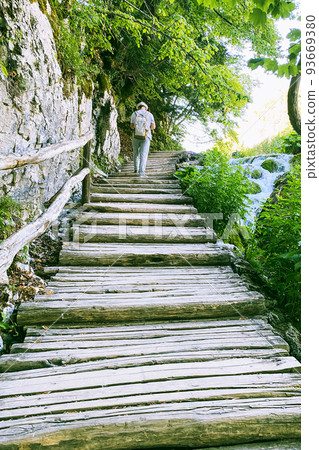 Wooden vintage bridge walkway along clean water. Summer landscapes in traveling. 93669380