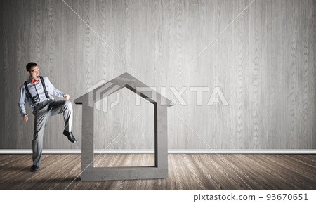 Stone home silhouette in empty room as symbol for real estate insurance 93670651