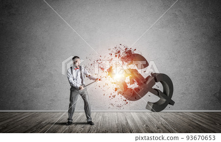 Determined banker man in empty concrete room breaking dollar figure 93670653