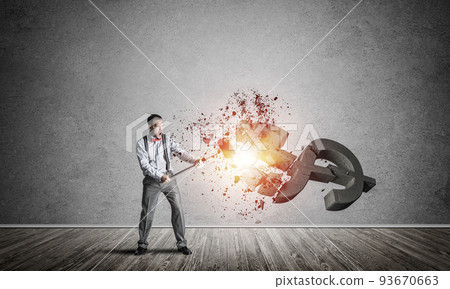 Determined banker man in empty concrete room breaking dollar figure 93670663