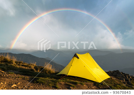 Yellow tent against the backdrop of an incredible mountain landscape 93670843