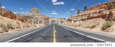 Scenic Road in the Dry Desert with Red Rocky Mountains in Background 93671951