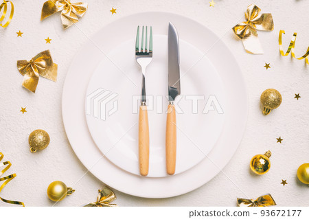 Christmas table place setting with christmas decor and plates, kine, fork and spoon. Christmas holiday background. Top view Christmas table place setting with christmas decor and plates, kine, fork and spoon. Christmas holiday background. Top view 93672177