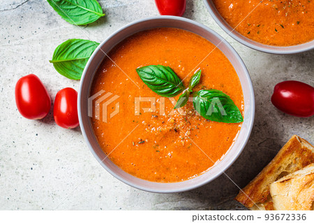 Traditional gaspacho in gray bowl. Summer tomato soup with basil. 93672336