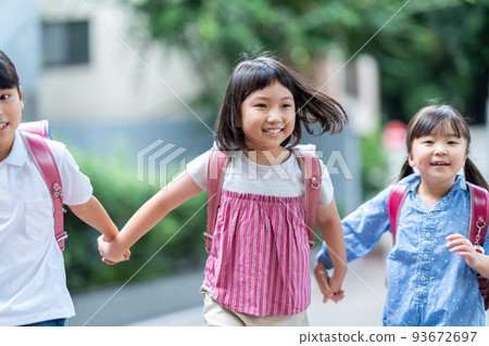 與朋友手牽手上學的小學生。 93672697